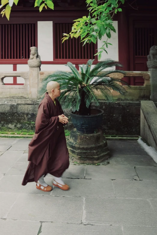 a monk walking down a sidewalk next to a building