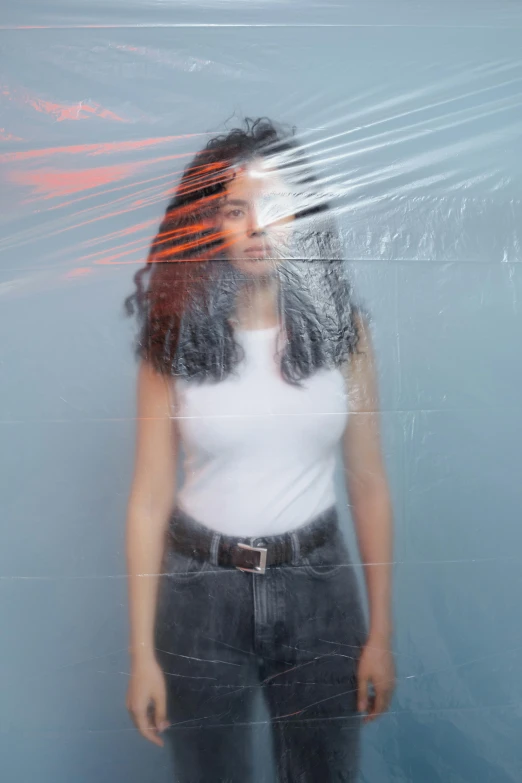 the woman is posing for the camera in front of the glass