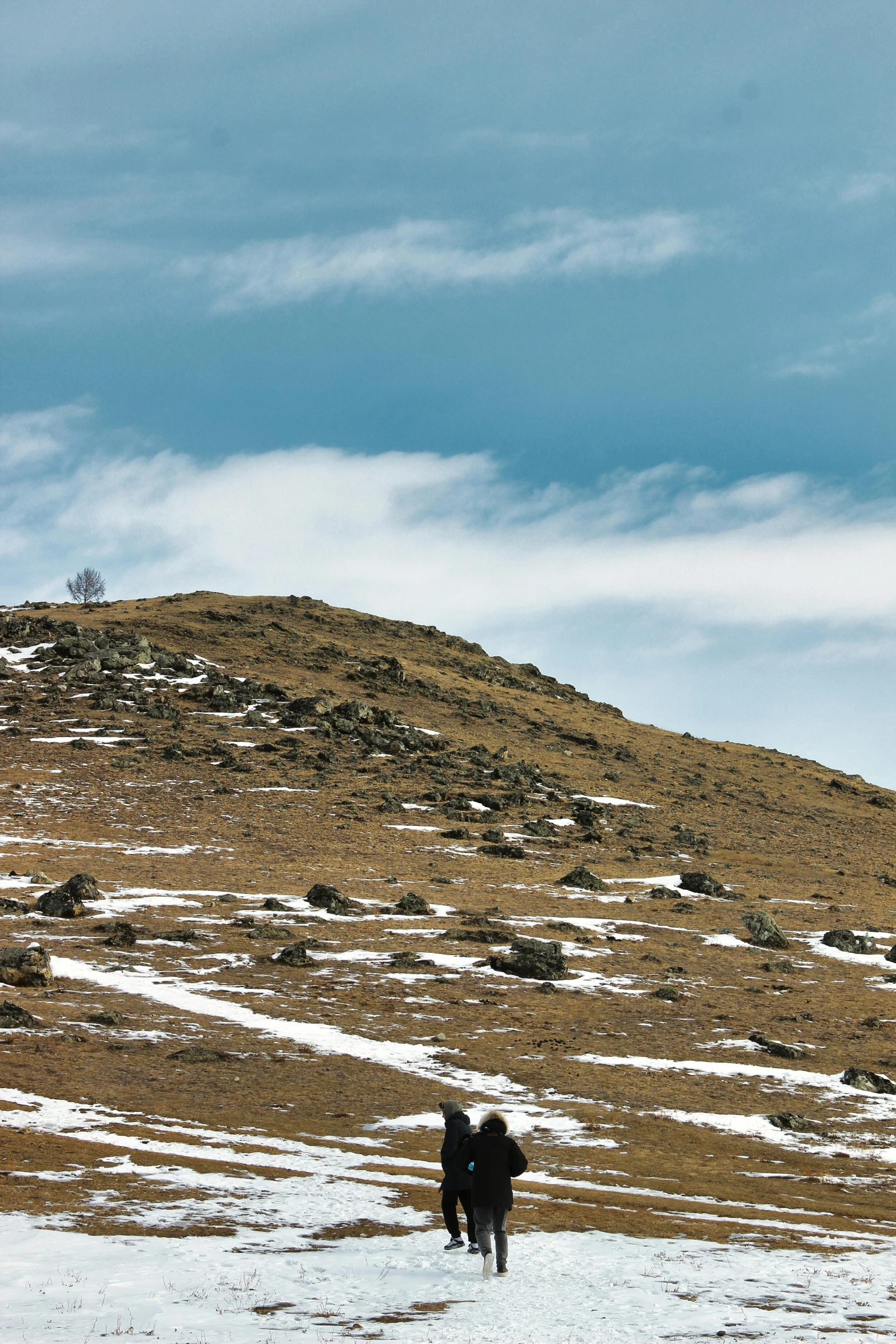 two people in the snow with a mountain in the background