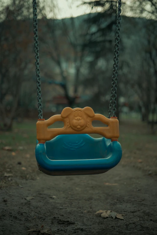 a plastic swing in a park with trees