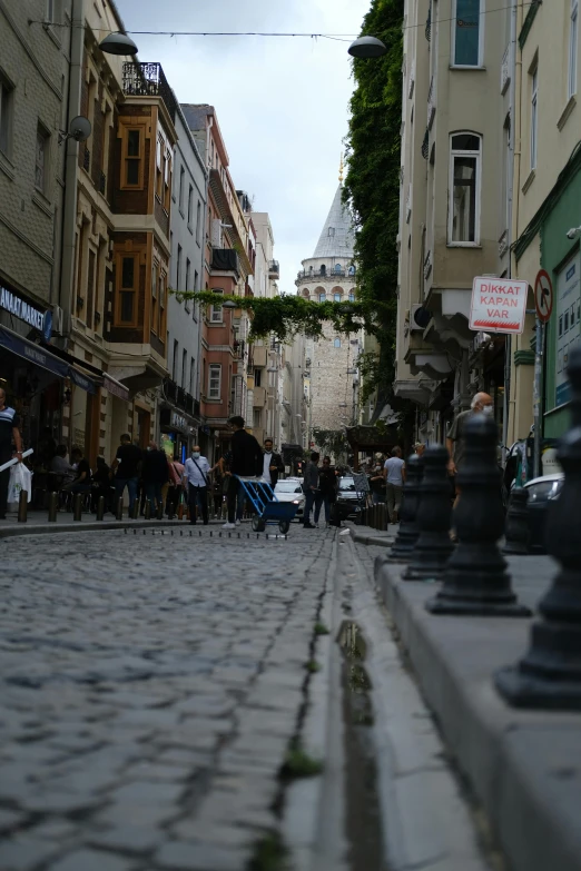 a paved city street is busy with people