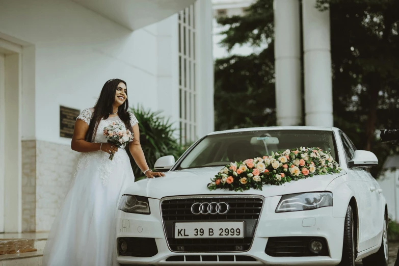 a couple pose in front of a car