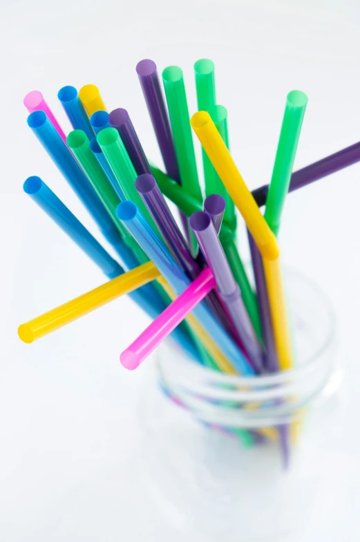 many colored plastic drinking straws in a glass