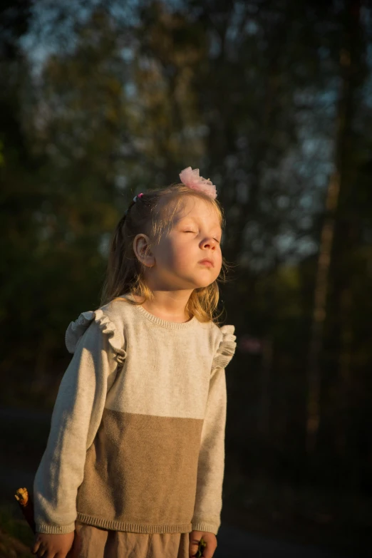 the little girl stands on the side of the road