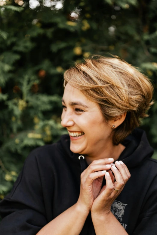 woman wearing black with white ring smiling at soing