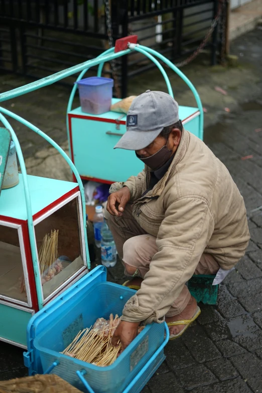 a man wearing a face mask prepares food