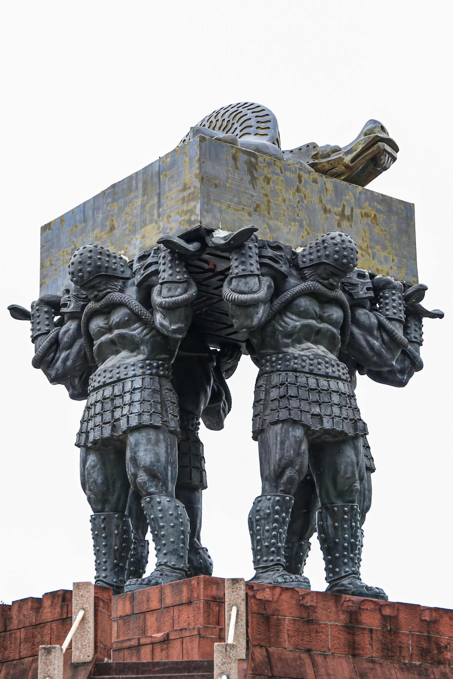 statue of a group of armored men standing in front of a brick pillar