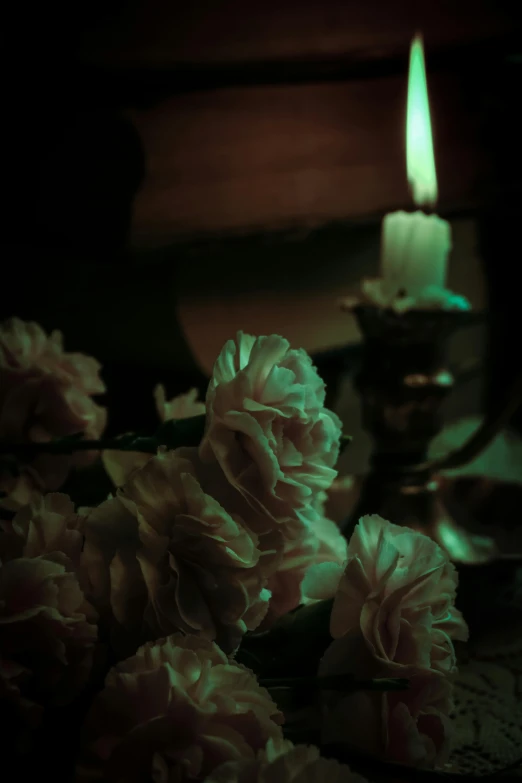 a lit candle is surrounded by pink flowers