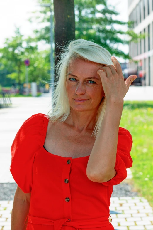 a woman with blonde hair wearing an orange top