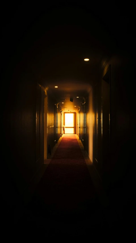 an dimly lit hallway between two buildings with the light streaming through