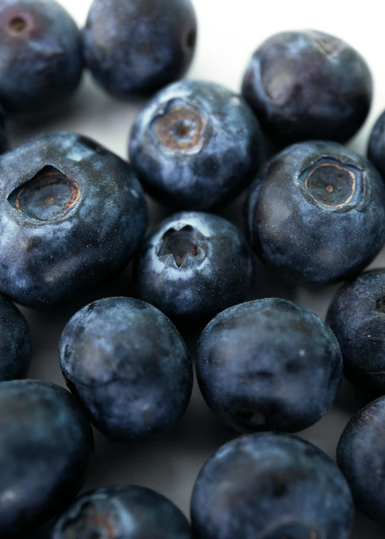 a bunch of blueberries piled high on a table