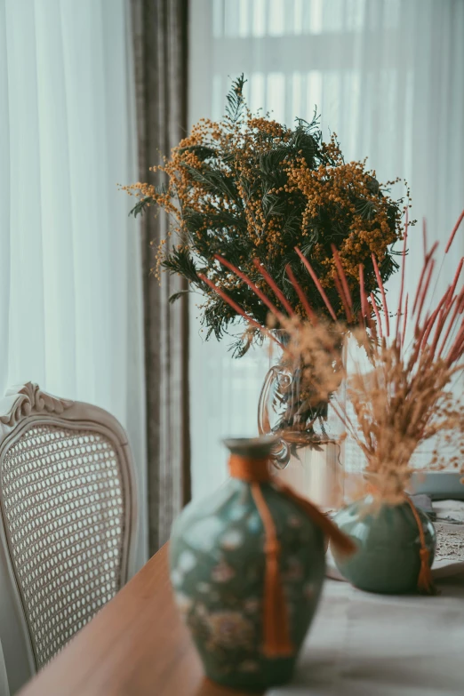 several vases and flowers sit on the table