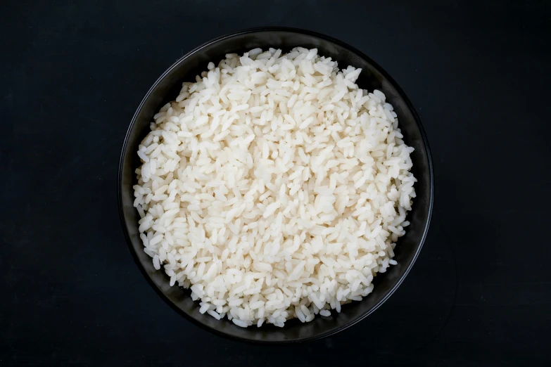 a small black bowl filled with cooked rice