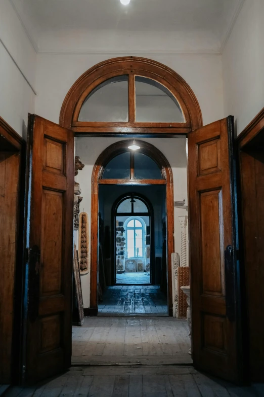 an empty hallway with dark wood doors in the center