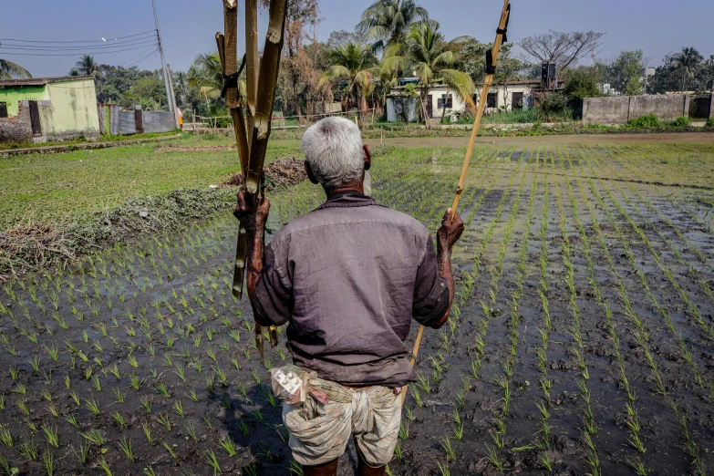 an old man on a farm with a pole