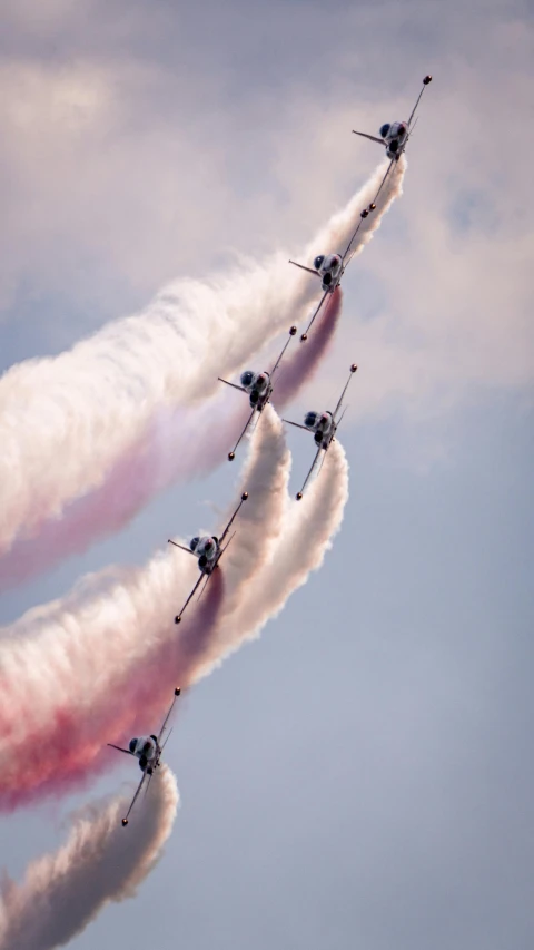 four airplanes in formation leaving a trail of smoke