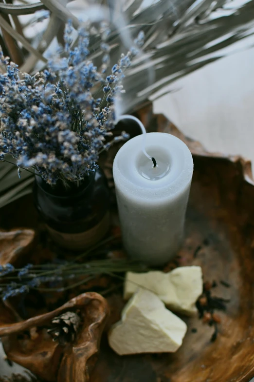 a white candle on top of a table next to small glass vases