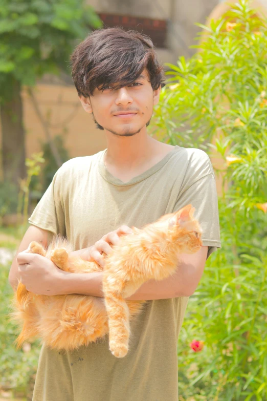 a young man holds his cat in his arms