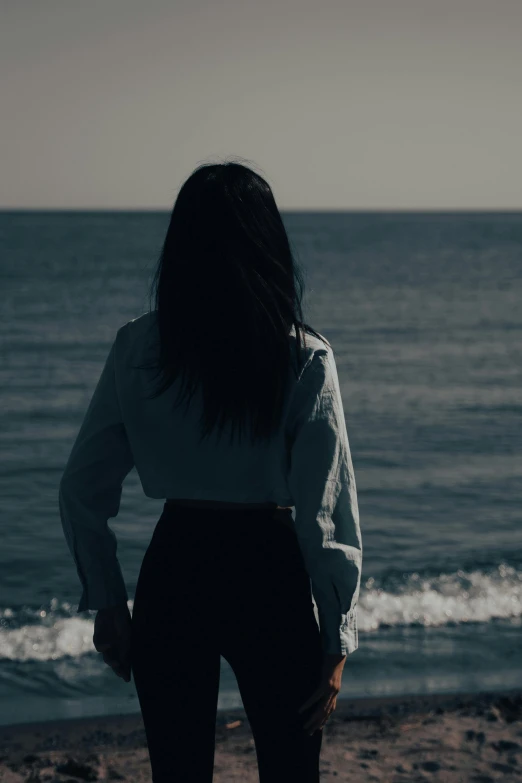 a person is standing on the shore watching the water