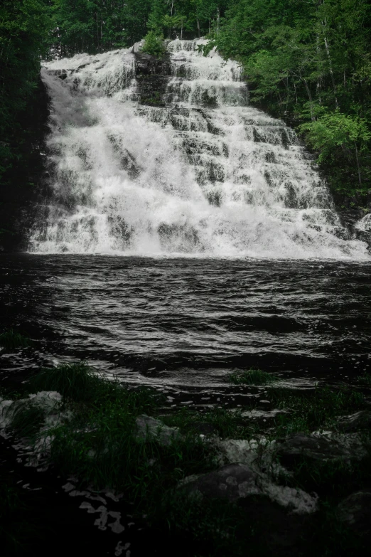 a group of people wading in front of a waterfall