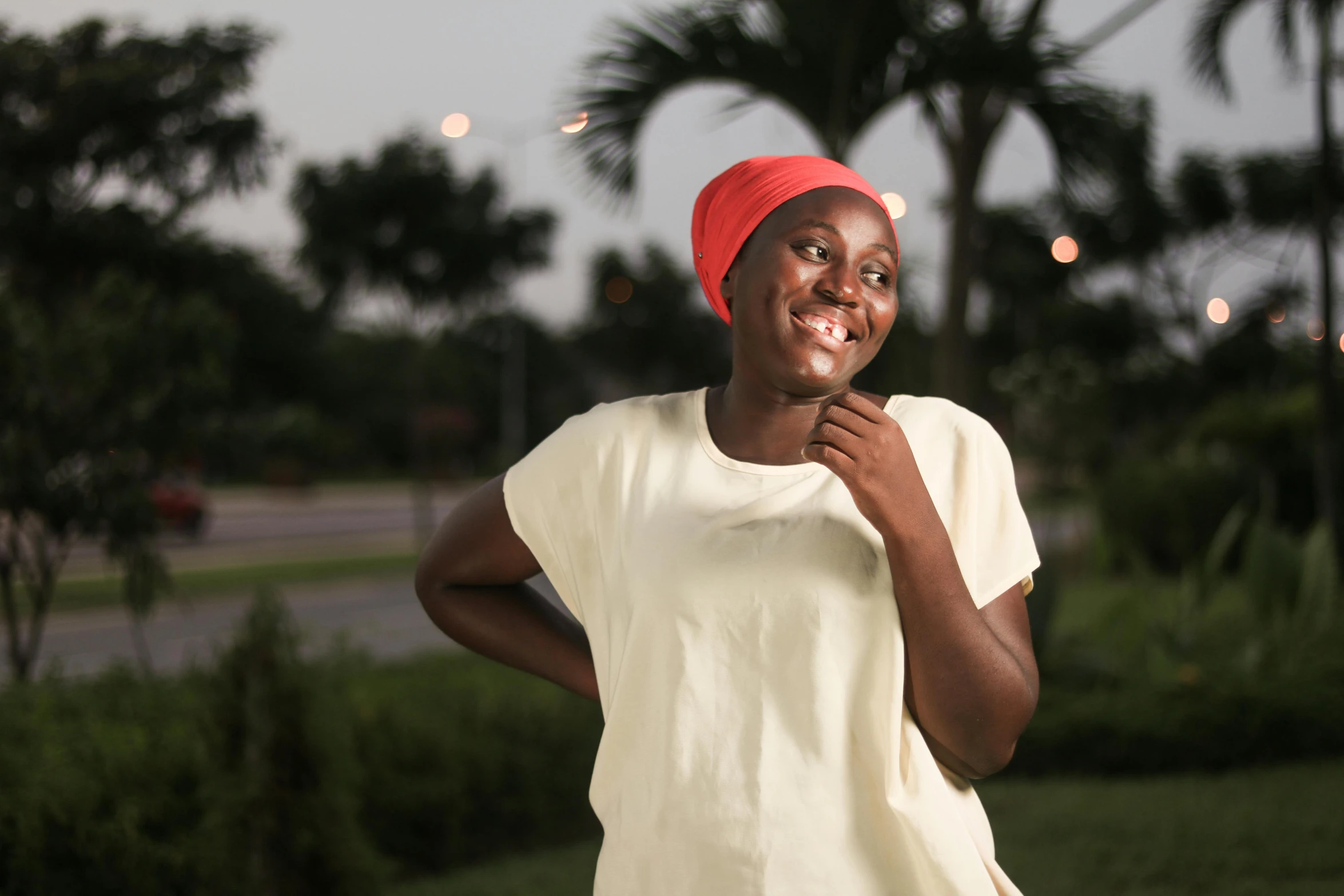 a smiling woman in yellow with a red hat