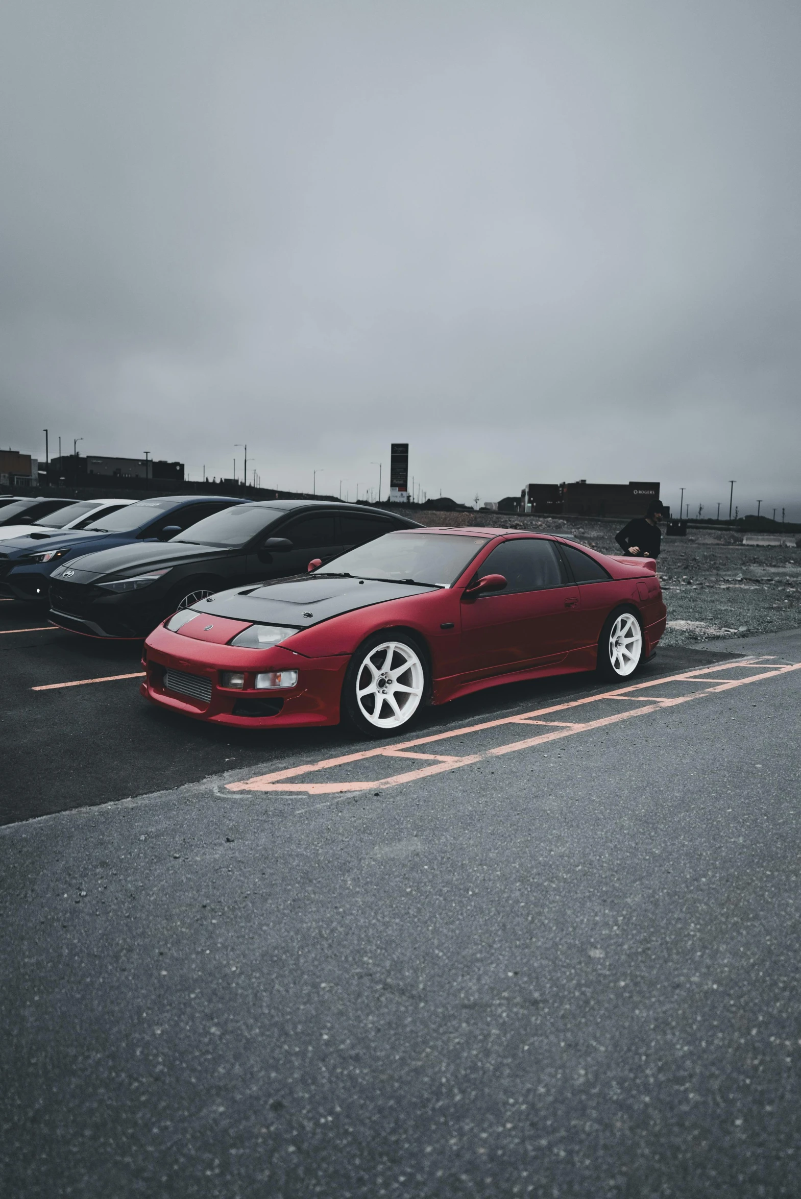 the red sports car is parked outside the parking lot