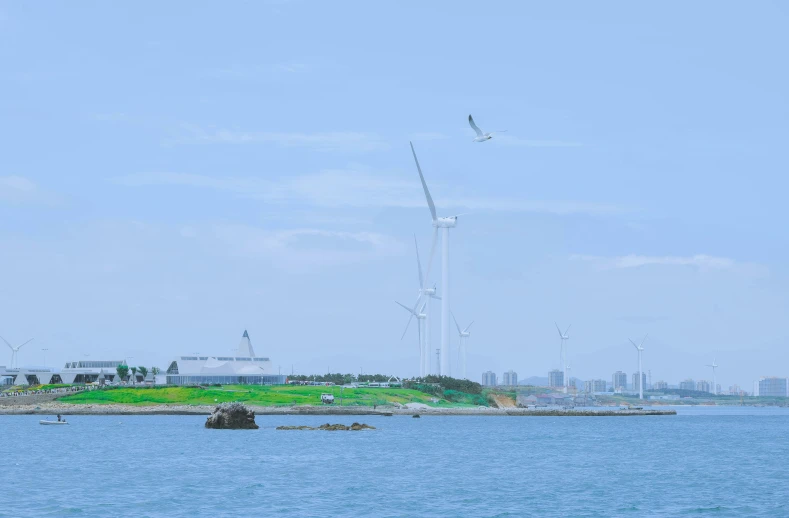 a body of water surrounded by two wind mills