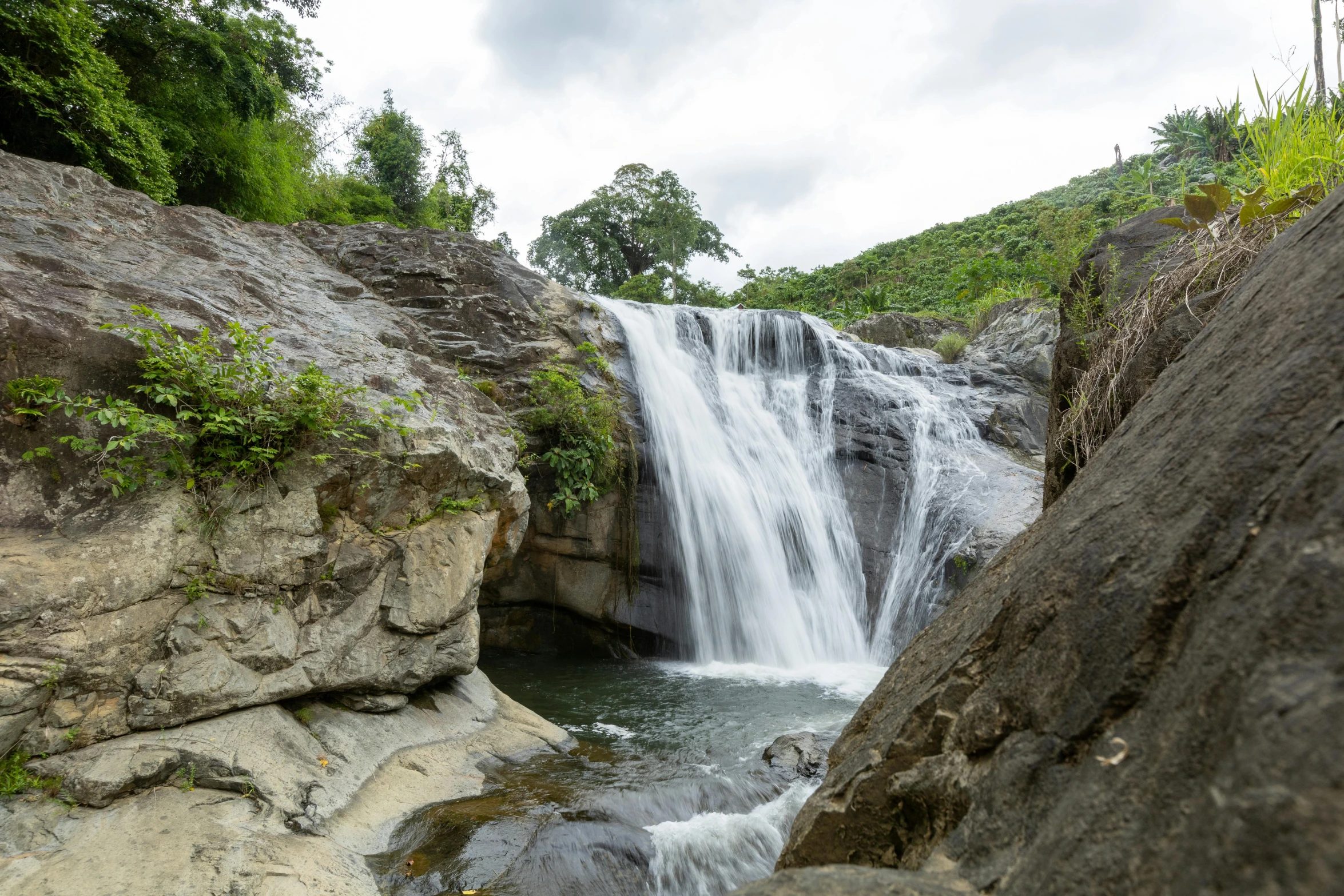 waterfall coming down from a cliff into the river