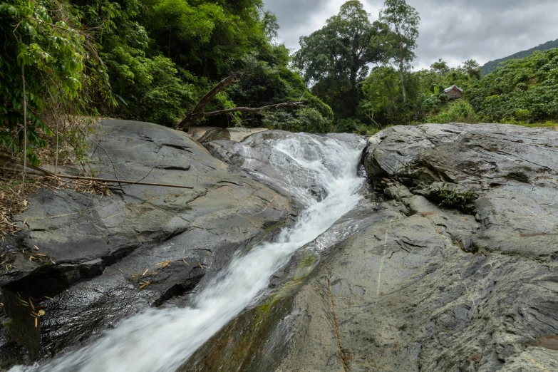 the waterfall in the jungle is flowing over rocks