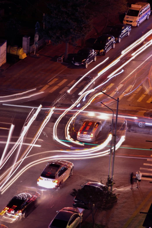 cars driving through a city street at night time