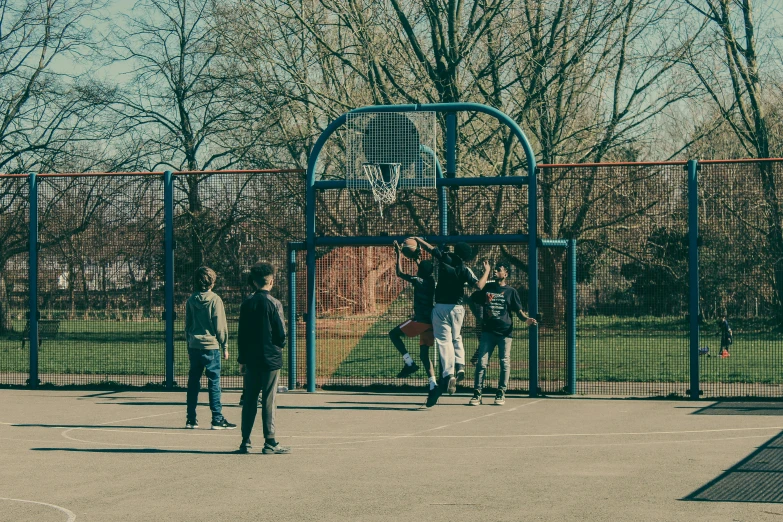 people are playing basketball in an empty basketball court