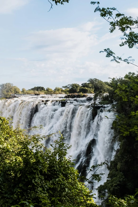 the water flows over the side of a large waterfall