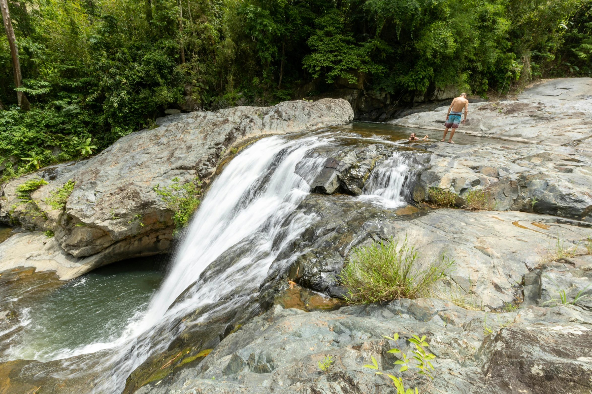 the man is standing on the rocks by the water