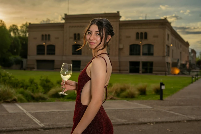 a woman in a red dress holds a wine glass