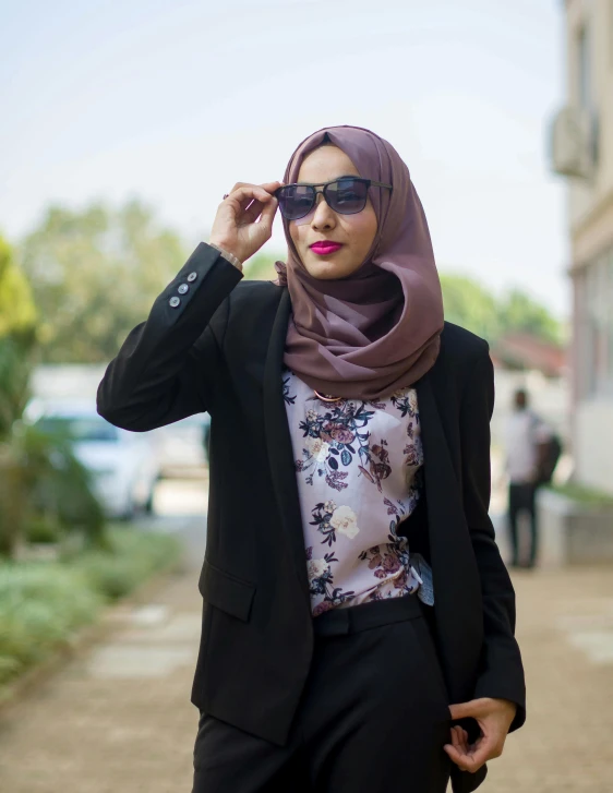 a woman with a scarf wearing a suit and sunglasses