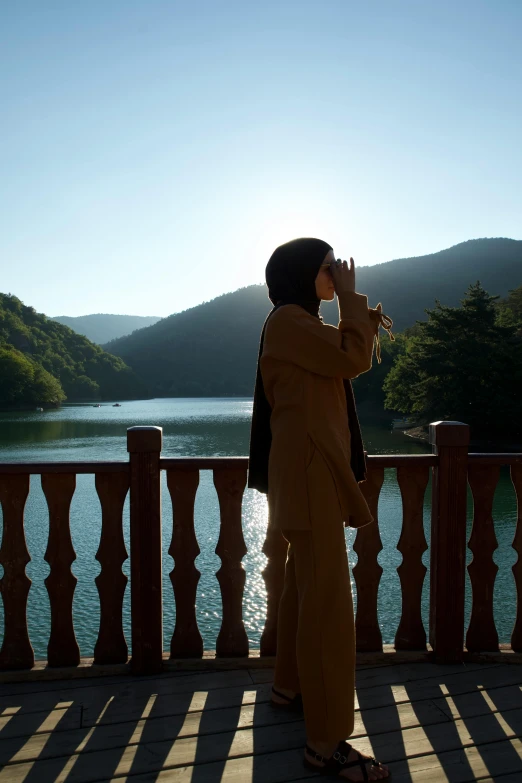 the woman is standing on the balcony overlooking the water