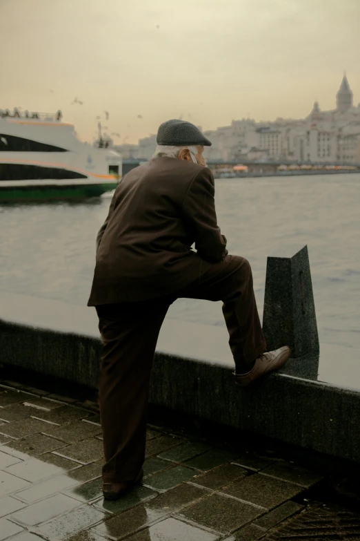 a man with an umbrella is sitting on a ledge