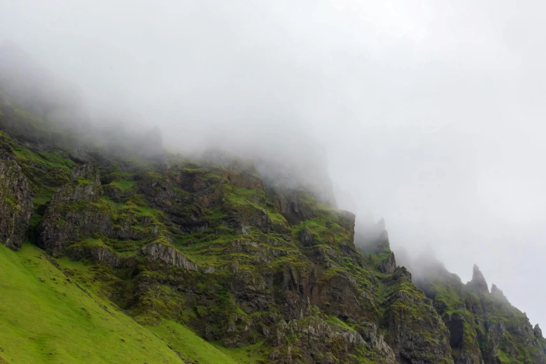 foggy, steep hill top covered in grass