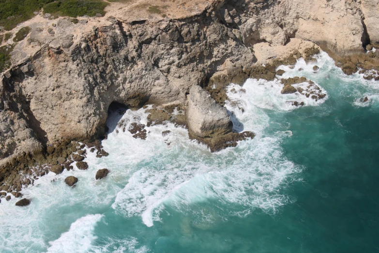 a large rock formation in the ocean with waves coming up to it