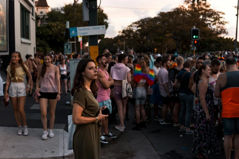 a woman standing on the side walk talking on her phone