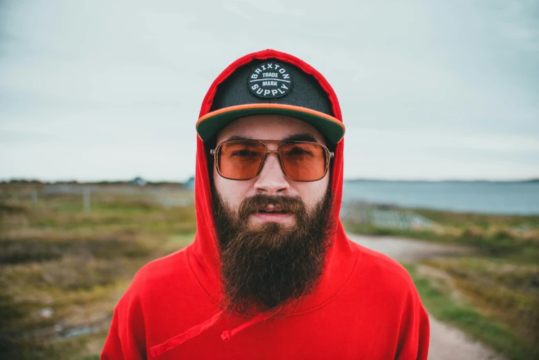 a man with a red sweatshirt, red hoodie, and a black starbucks cap