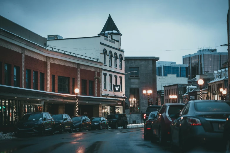 a city street is lined with cars and tall buildings