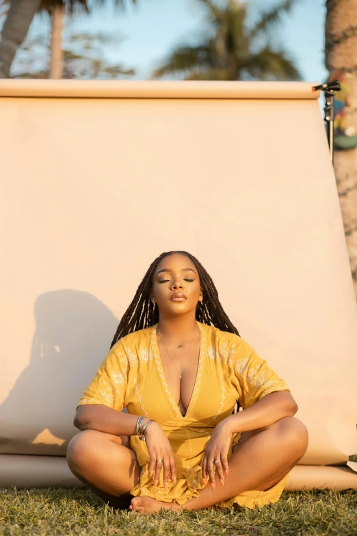 a woman in yellow outfit sitting in grass