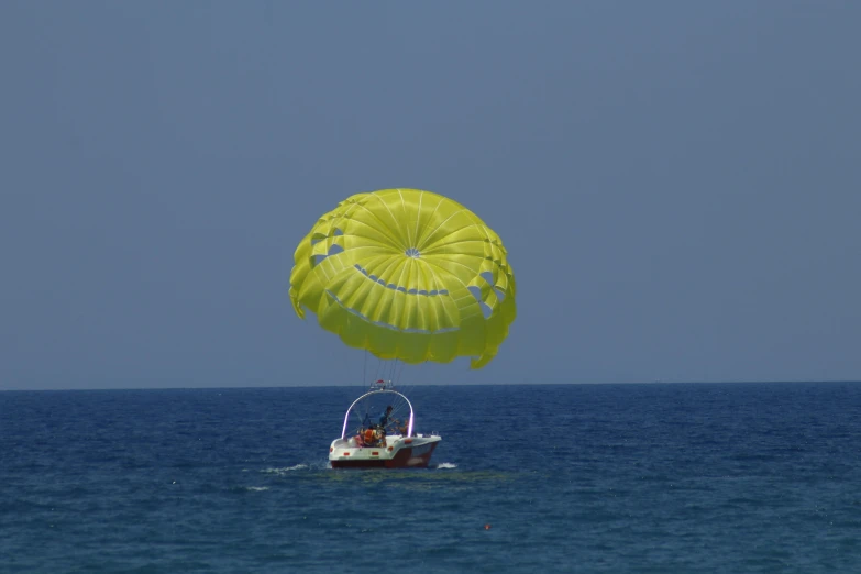 a large yellow kite flies in the air over the ocean