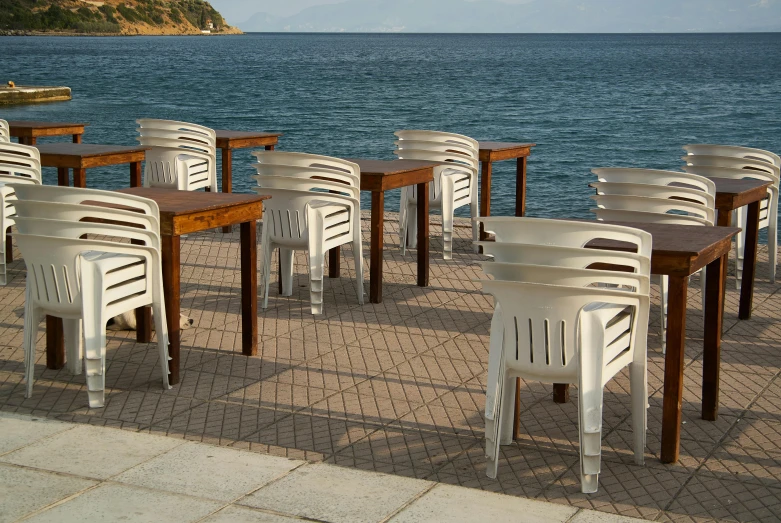 white plastic chairs and tables overlooking the water