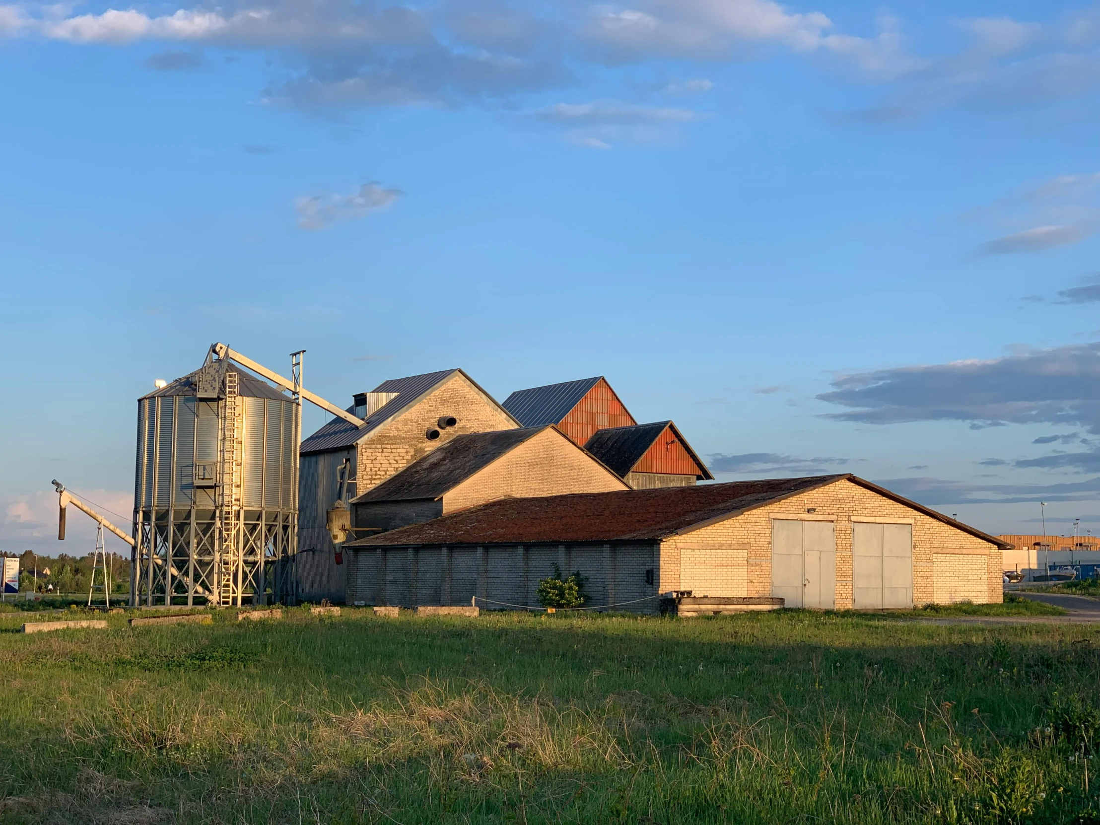 a large grain bin sitting in a lush green field