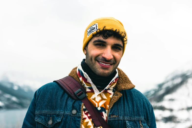 a man wearing a hat and a scarf posing for the camera