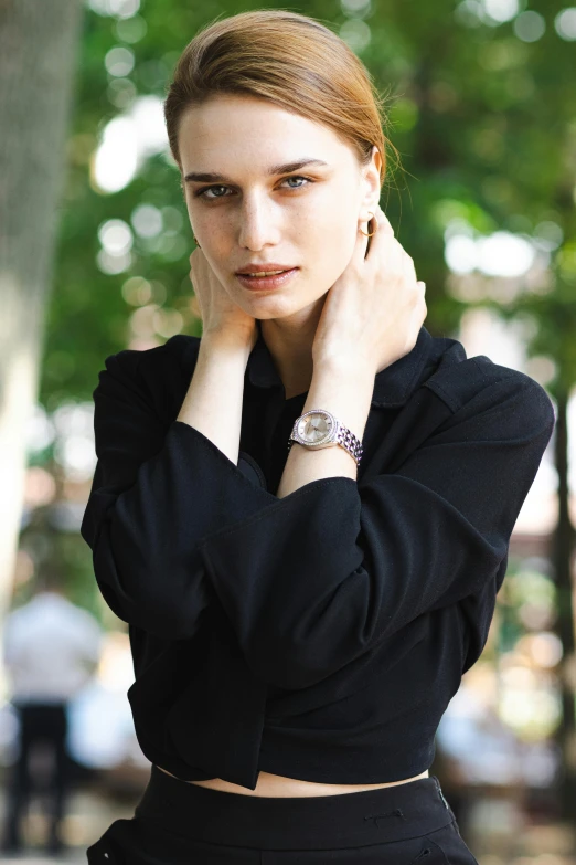 a woman in a black dress posing on the street