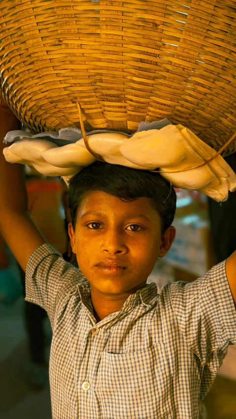 a  carrying a large basket on his head