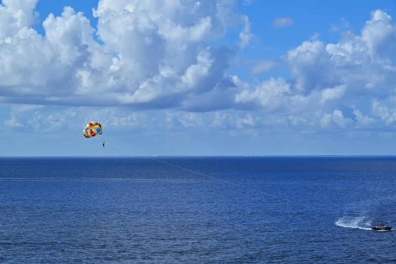 a parachute over the ocean on a sunny day